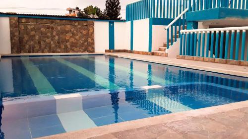 einen Pool mit einem blauen und weißen Zaun in der Unterkunft Hostal SAMARY in Atacames