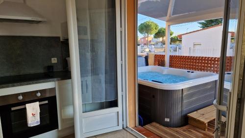 a tub in a kitchen with a view of a patio at rêve méditerranéen, Le bonheur est dans ma maison in Le Barcarès