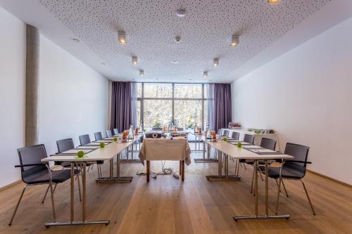a conference room with tables and chairs and a large window at Das Graseck - mountain hideaway & health care in Garmisch-Partenkirchen