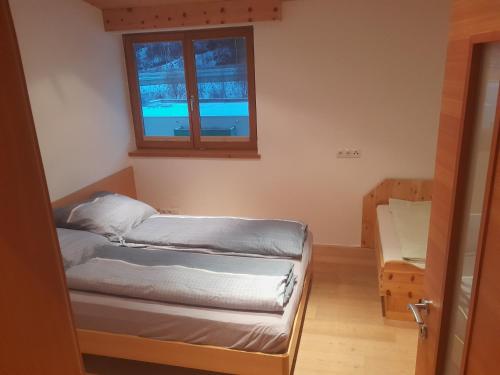 Kleines Zimmer mit einem Bett und einem Fenster in der Unterkunft Haus Hotz Apart Talblick in Grins