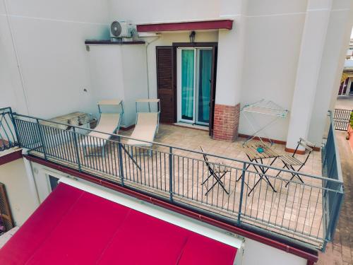 a balcony with two chairs and a red rug at B&B De Angelis in Ginosa Marina