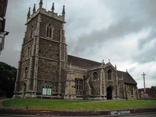 an old stone church with a tower on the grass at The Windmill Hotel in Lincolnshire