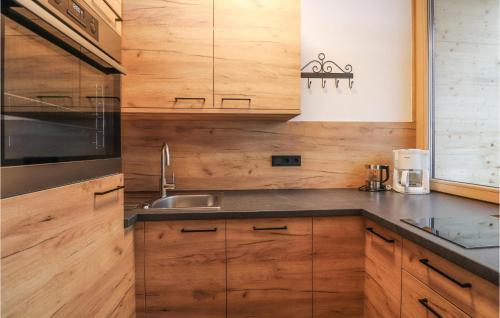 a kitchen with wooden cabinets and a sink at Nice Apartment In Maria Alm Am Steinernen With Wifi in Bachwinkl