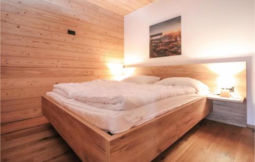 a bed in a room with a wooden wall at Nice Apartment In Maria Alm Am Steinernen With Wifi in Bachwinkl