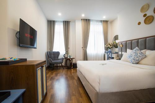 a hotel room with a bed and a flat screen tv at Western Hanoi Hotel in Hanoi