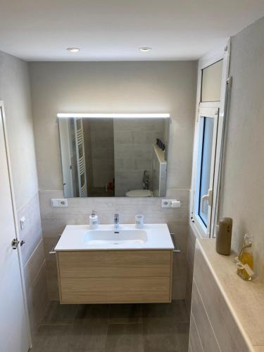 W łazience znajduje się umywalka i lustro. w obiekcie Calafell Residencial w mieście Calafell