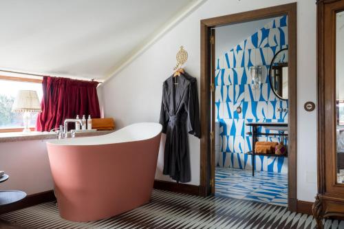 a bathroom with a bath tub next to a window at Casa Beatnik Hotel in Santiago de Compostela