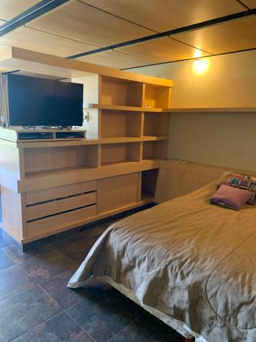 a bedroom with a bed and a flat screen tv at Apart Club San Pedro in San Pedro