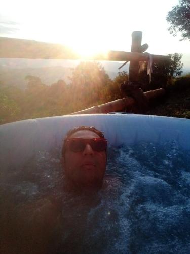 a person with sunglasses in a pool with a surfboard at Refugio Mirador del Ocaso in Zipacón