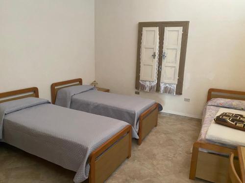 a room with two beds and a window at Baràka - Bungalow sulla spiaggia in Donnalucata