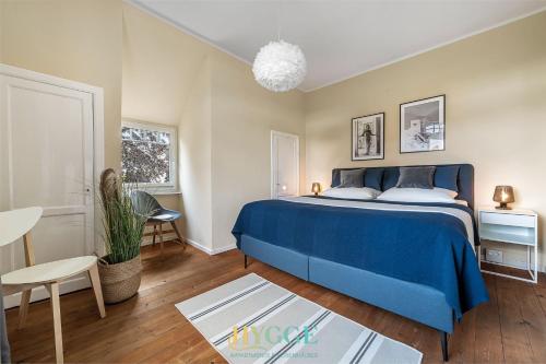 a bedroom with a blue bed and a table at Villa Hygge in Kappeln - Design Ferienwohnungen mit Saunawagen in Kappeln