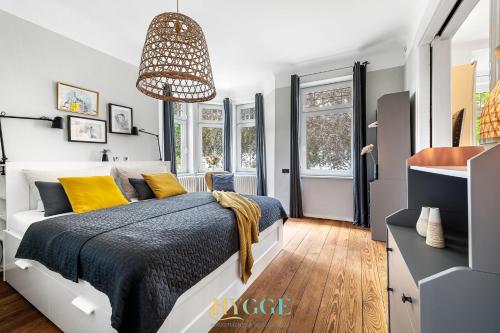 ein Schlafzimmer mit einem großen Bett mit gelben Kissen in der Unterkunft Villa Hygge Kappeln - Ferienwohnungen in Kappeln
