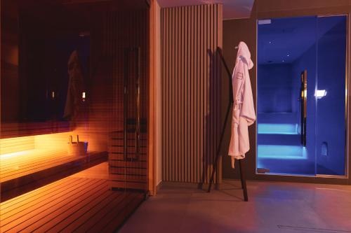 拉韋洛的住宿－Moma Hotel Wellness & Spa，浴室的杆子上挂着一件长袍