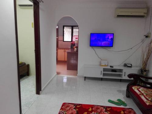 - un salon avec une télévision sur un mur blanc dans l'établissement Idaman guesthouse Malay only, à Kubang Semang