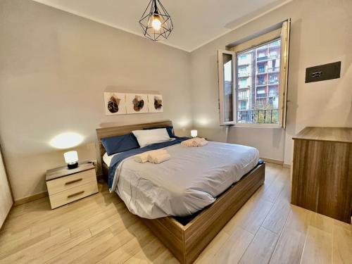 sypialnia z dużym łóżkiem i oknem w obiekcie [Metro-apartment]: fabolous flat w mieście Moncalieri