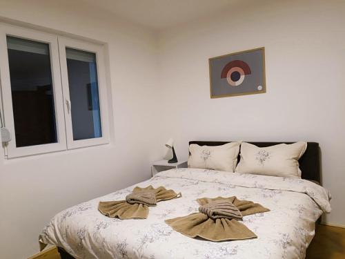 Apartmani Mir A2 في Vrnjačka Banja: غرفة نوم عليها سرير وفوط