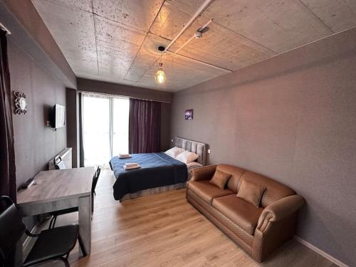 une chambre avec un lit, un canapé et une table dans l'établissement Gudauri Twins Beauty 239, à Goudaouri