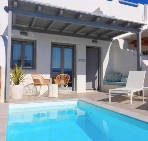 una piscina con pergolato e sedie accanto a una casa di The Nine Graces - Agia Anna - Option With private pool or hot tub ad Agia Anna Naxos