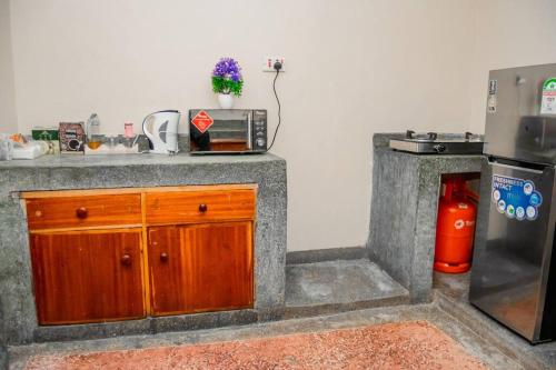 a kitchen with a counter with a microwave and a refrigerator at Jenna stays in Nyeri