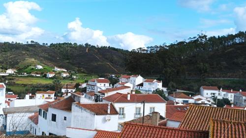 eine Gruppe weißer Häuser mit Bergen im Hintergrund in der Unterkunft SulSeixe Guesthouse in Odeceixe