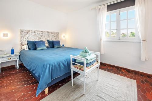 Un dormitorio con una cama azul y una ventana en Casa Guatifay en Puerto del Carmen