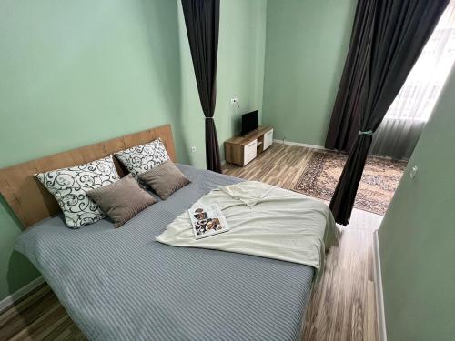 Un dormitorio con una cama con almohadas. en SN Apartments en Osh