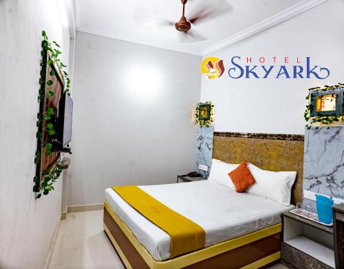 a bedroom with a bed and a sign on the wall at Hotel Skyark in Kanyakumari
