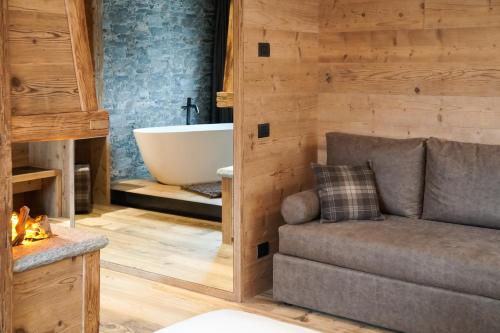 a bathroom with a couch and a bath tub at Sci Sport rooms & suites in Bormio