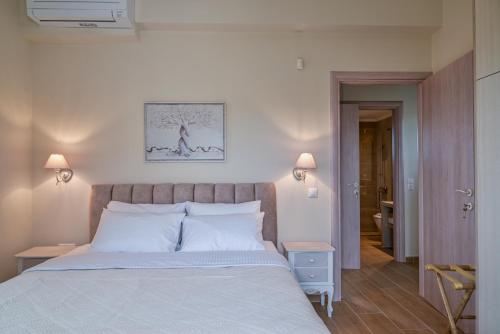 a bedroom with a large bed with white pillows at EFMAR EXCLUSIVE RESIDENCES in Gythio