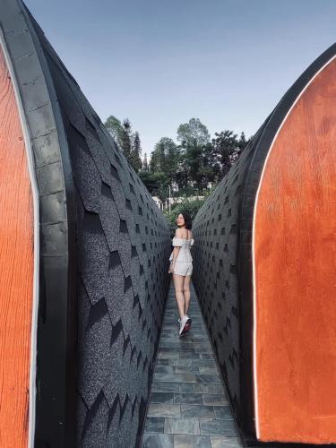 a woman walking across a large tire bridge at Plum Homestay in Dồng Văn