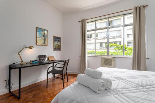1 dormitorio con escritorio, 1 cama y ventana en Unhotel - Maravilhoso Apartamento Por Temporada em Copacabana, Perto da Praia, en Río de Janeiro