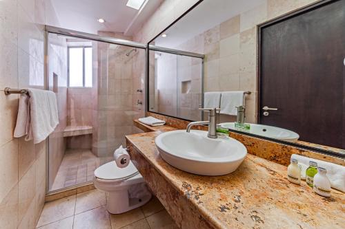a bathroom with a sink and a toilet and a shower at Suites Teca Once in Mexico City