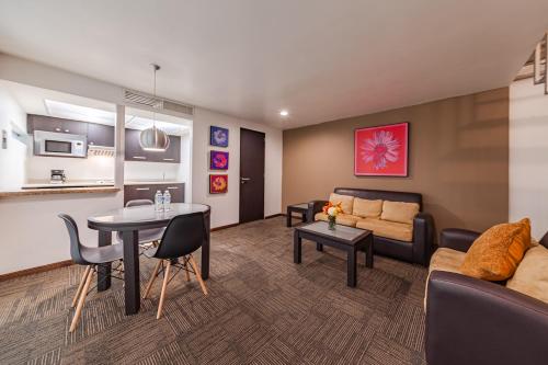 a living room with a couch and a table at Suites Teca Once in Mexico City