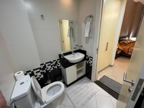 een badkamer met een wit toilet en een wastafel bij Large size one bedroom apartment with sea view in Abu Dhabi