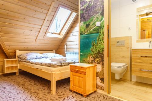 een slaapkamer met een bed en een toilet in een kamer bij Leśna Ostoya in Białka Tatrzanska