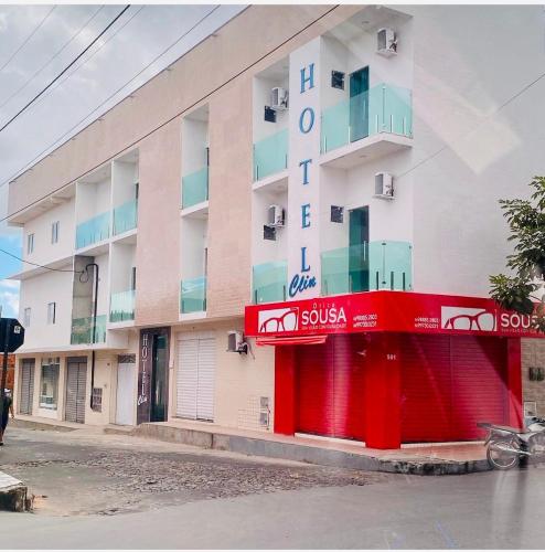 a large white building with a red facade at Hotel Clin Acaraú in Acaraú