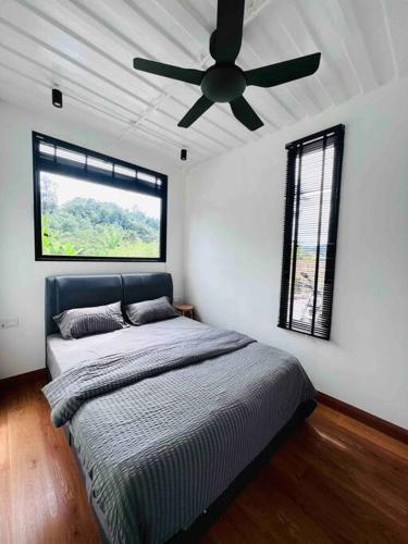 a bedroom with a bed and a ceiling fan at The Black Box Villa - Genting Highland Foot Area in Bentong