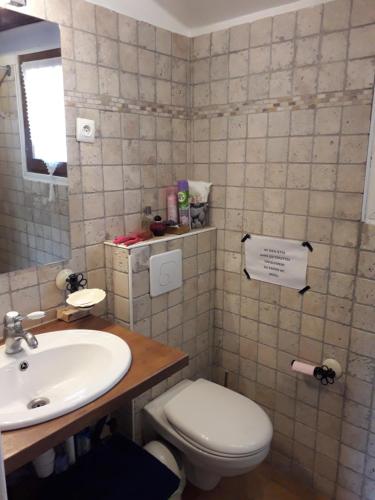 a bathroom with a white toilet and a sink at Marcolline in Rians