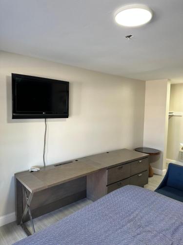 ハンプトンにあるEconomy 7 Inn Hamptonの壁にテレビとベッドが備わる客室です。