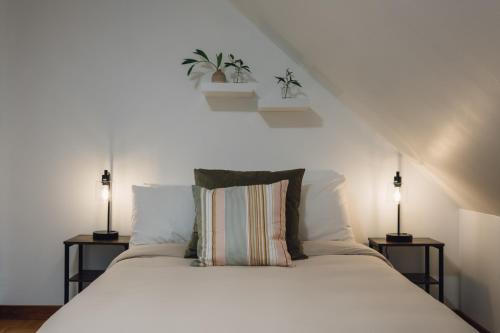 um quarto com uma cama branca e 2 candeeiros em Chalet du Sous-Bois By My Tremblant Location em Saint-Faustin