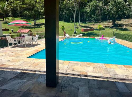 una piscina con cisnes en el agua en Chalé em Pousada Recanto MD, en Itaboraí