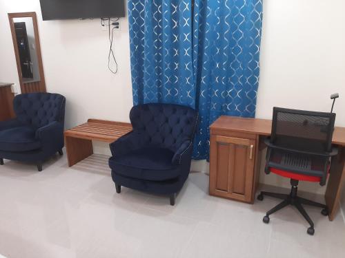 a room with two chairs and a table and a desk at PESHERES INN & SPA in Bon Accord