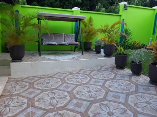 a green wall with plants and a bench on a patio at PESHERES INN & SPA in Bon Accord