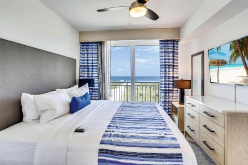 a bedroom with a bed and a view of the beach at Oceana 203 West in St. Pete Beach