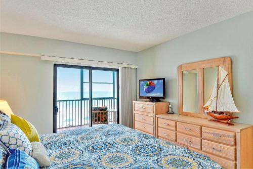 - une chambre avec un lit et une commode avec un miroir dans l'établissement Villa Madeira 307 - Premier, à St. Pete Beach