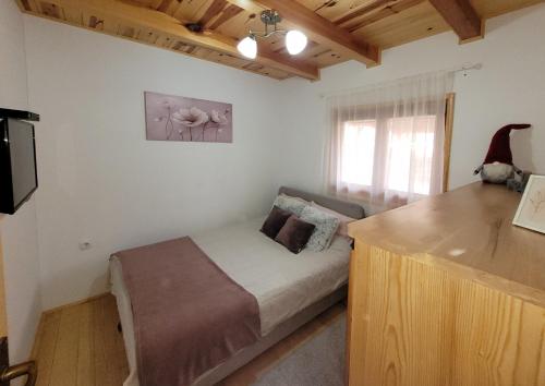 a small bedroom with a bed and a window at Apartmani D&S in Mokra Gora