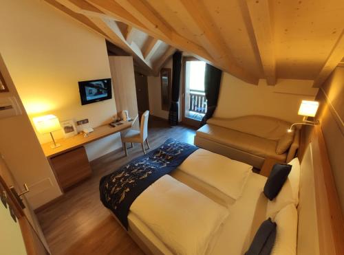 a bedroom with a bed and a desk in a room at Hotel Bondi in Livigno