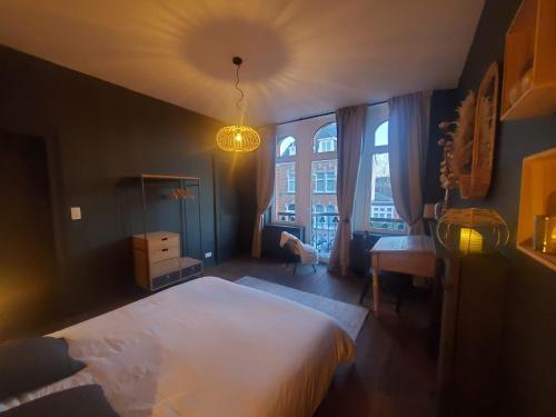 a bedroom with a large white bed and a window at Le Kiosque in Ciney