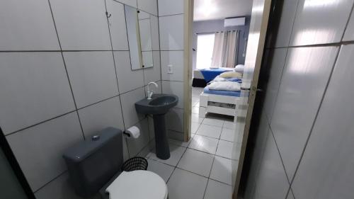 baño con lavabo y aseo y 2 camas en ZZZ BRUNO KLEMTZ - Residencial Recanto dos Pássaros Estúdio até 4 pessoas com ar Split wifi coz vaga, en Itapema