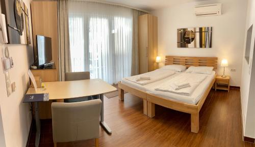 Schlafzimmer mit einem Bett, einem Tisch und einem Schreibtisch in der Unterkunft AJO Vienna Beach - Contactless Check-in in Wien